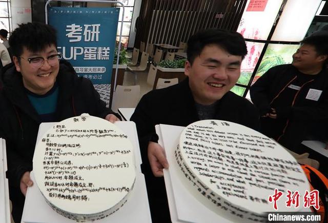 英語の文や数学の公式などが書かれた「暗記ケーキ」を見せる南京航空航天大学の大学生（撮影?泱波）。